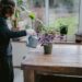 mujer cuidando plantas en su casa.